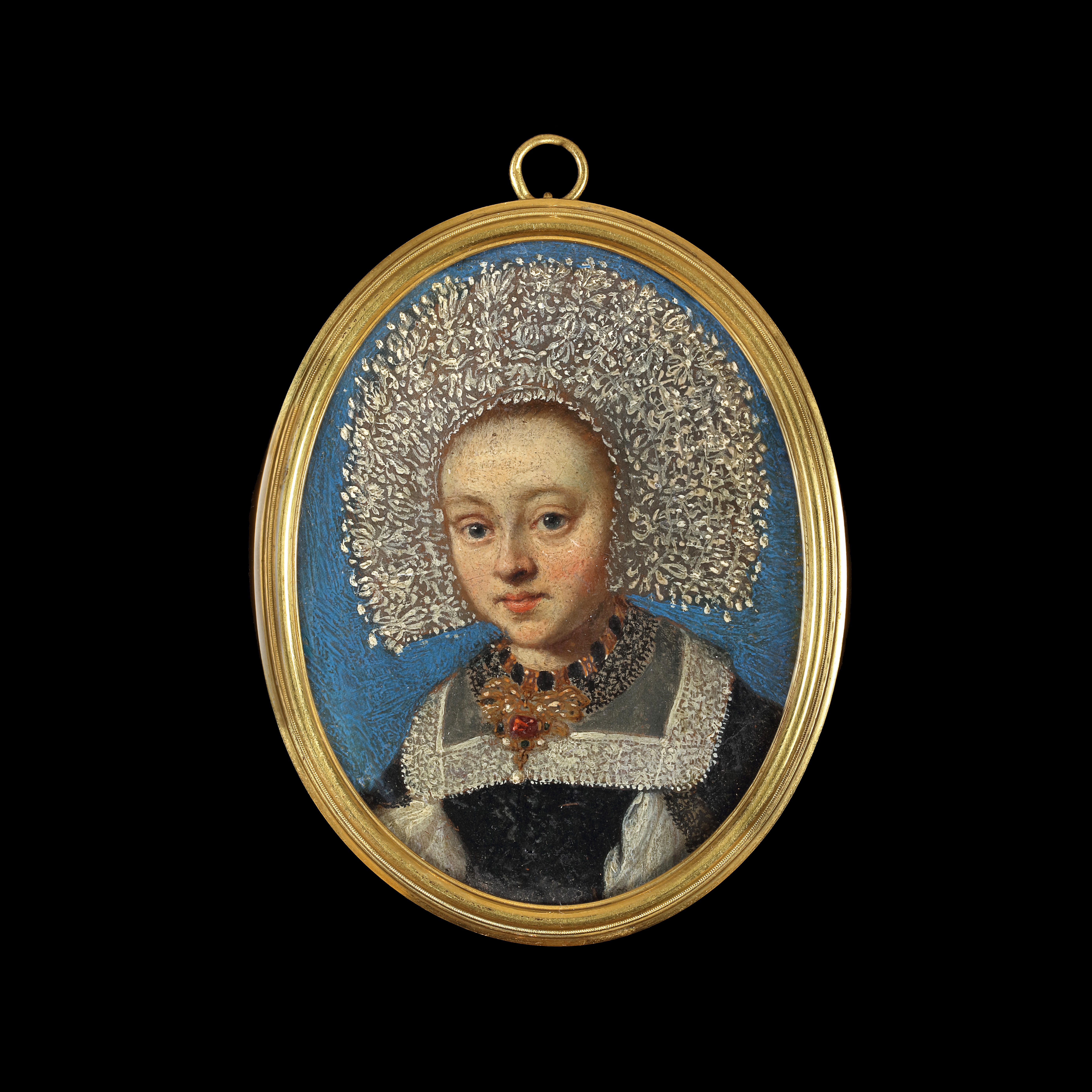 A lady, probably a bride, wearing black gown with white underdress, lace sleeves and lace-edged collar, an elaborate gold jewel in the shape of a ribbon set with a large ruby hangs from a gold collar at her neck; she also wears a lace ‘calotte’ or bonnet made from lace 