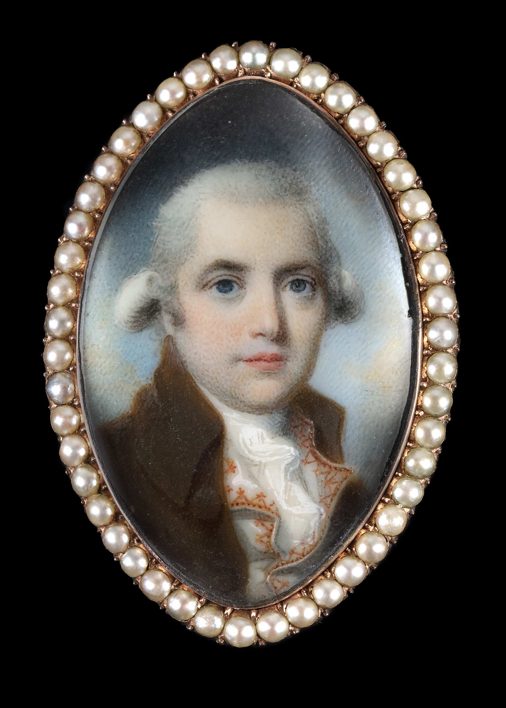 A portrait miniature of a Gentleman, wearing brown coat, white waistcoat with embroidered edging and white frilled shirt, his hair powdered