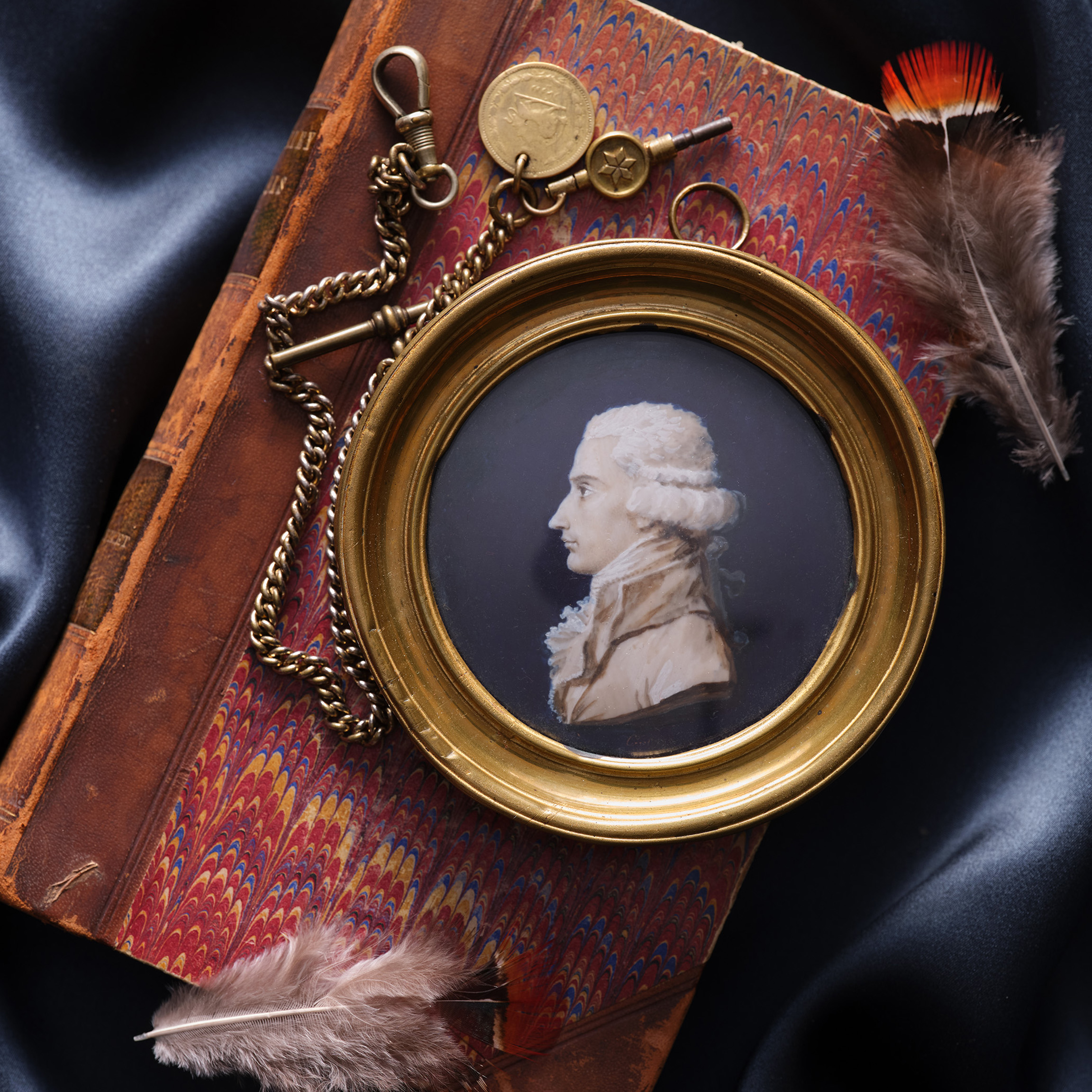 George-Fréderic Bapst (1756-1826), en buste, in profile to the left, in coat, waistcoat and frilled cravat, powdered hair en queue, painted in brown camaïeu heightened with white on a dark-blue ground