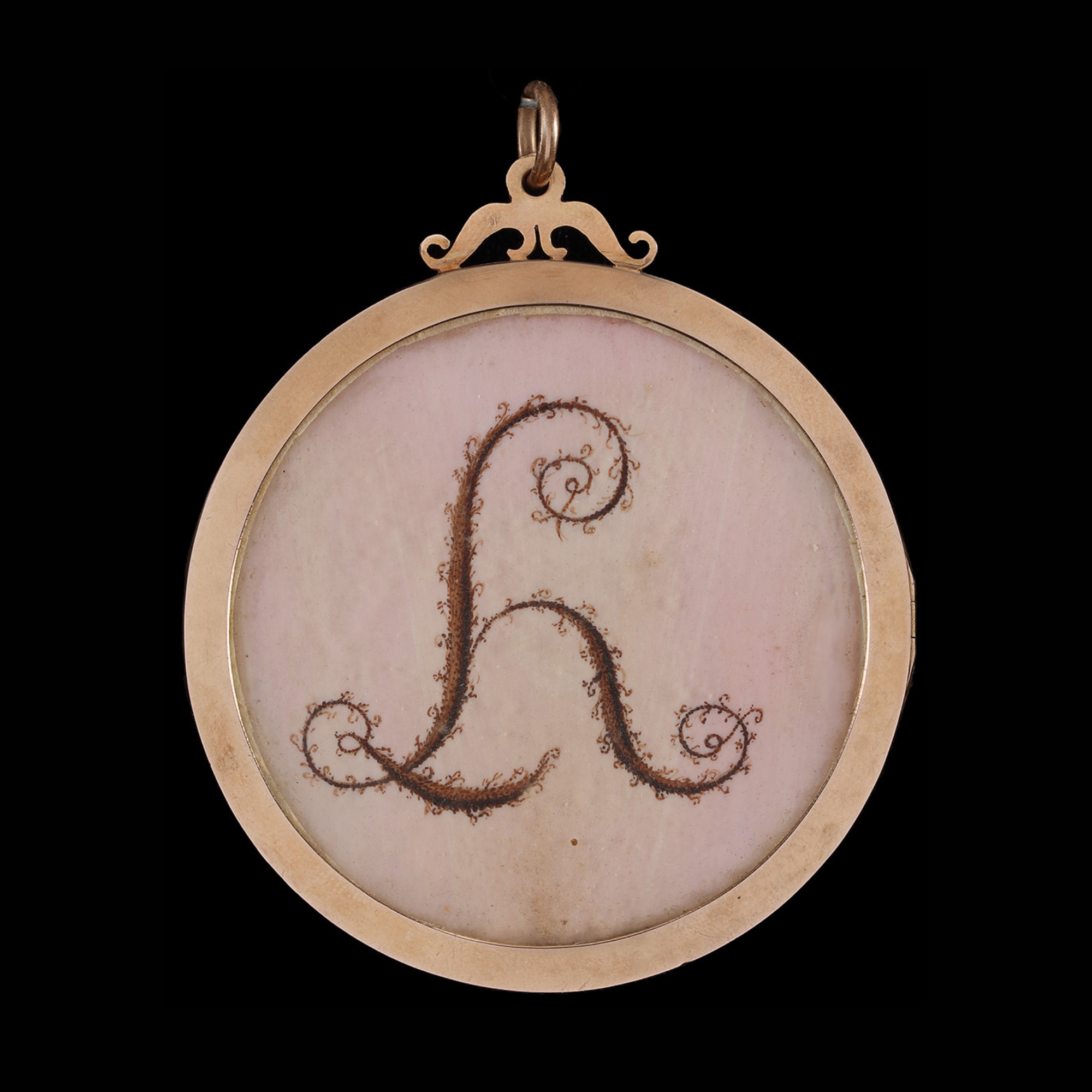 Portrait miniature of a Young Lady full face in white silk dress with riple frilled collar, pink bow at corsage, large hat adorned with pink roses, foliage and white ribbon in her powdered upswept hair; gold/gilt-metal frame, the reverse with foliate monogram 'LH' on pink ground