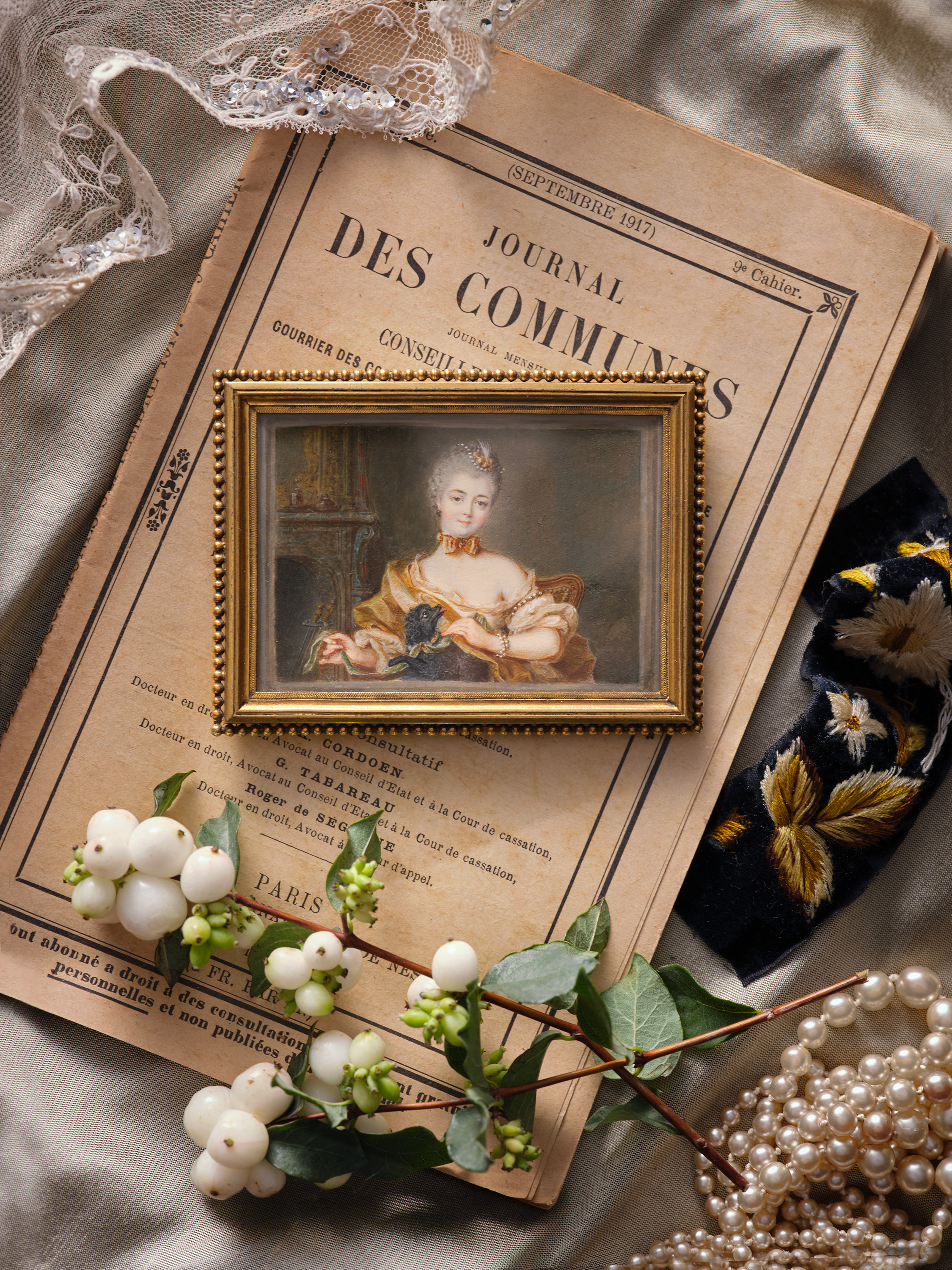 Portrait miniature of Madame de la Porte (Marie-Anne Pellerin de Painville) (1714-1763), wearing a gold silk shawl over a light pink chemise, pearls in her hair and across her arms, gold silk bow around her neck, with a dog on her lap, playing with a green ribbon