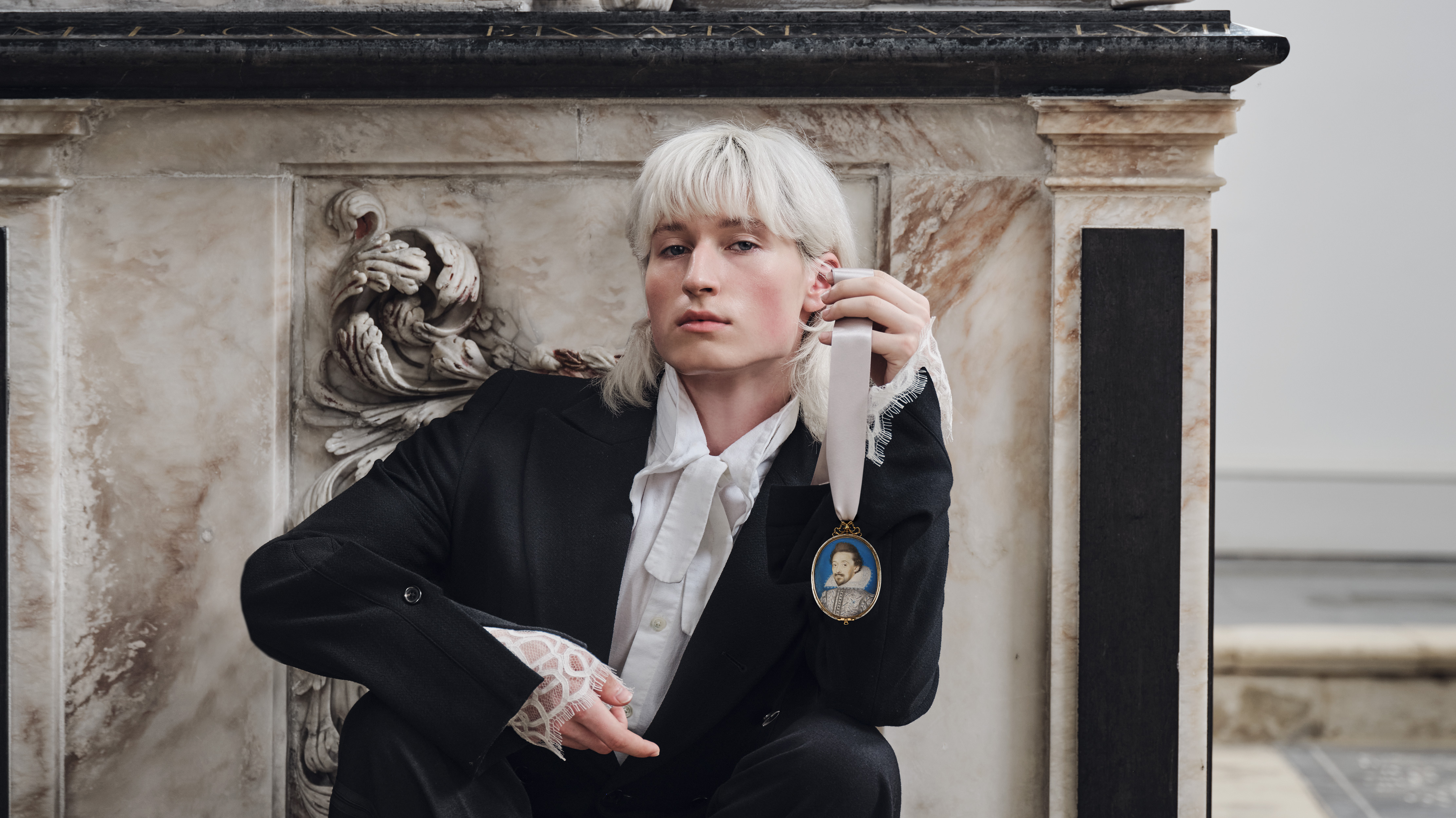 Portrait miniature of a Nobleman wearing a white doublet with embroidery and slashes, and a lace-edged rebato collar; blue background with gold border